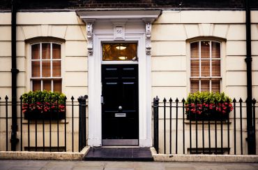 Georgian townhouse with black door and red flower boxes